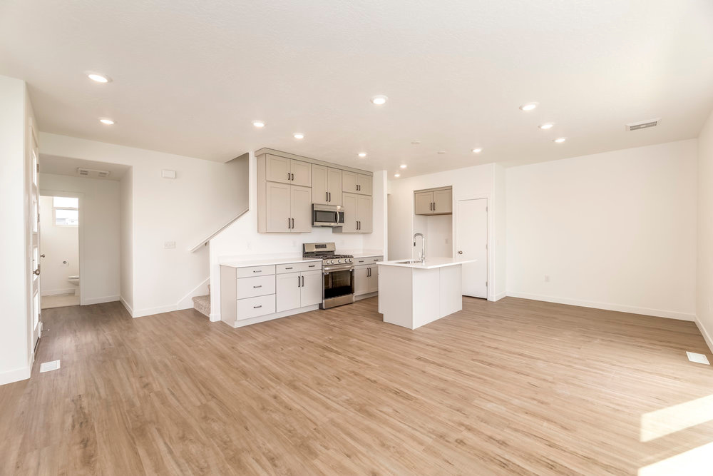 Kitchen featuring appliances with stainless steel finishes, open floor plan, recessed lighting, light wood-style flooring, and baseboards