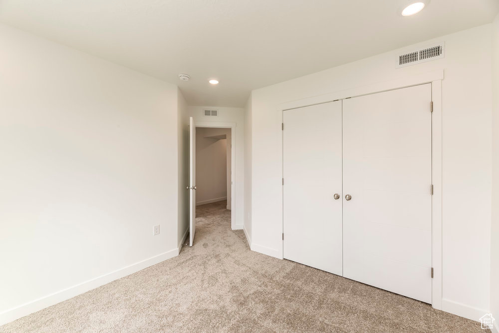 Unfurnished bedroom with carpet flooring, recessed lighting, baseboards, and a closet