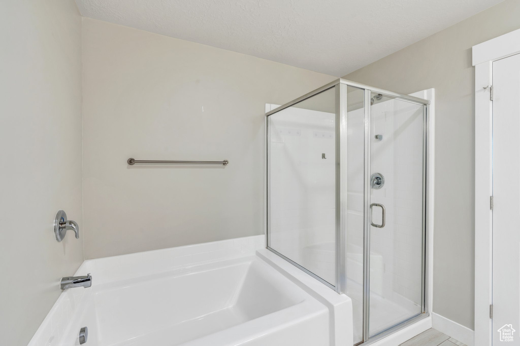 Full bathroom featuring a stall shower and a garden tub