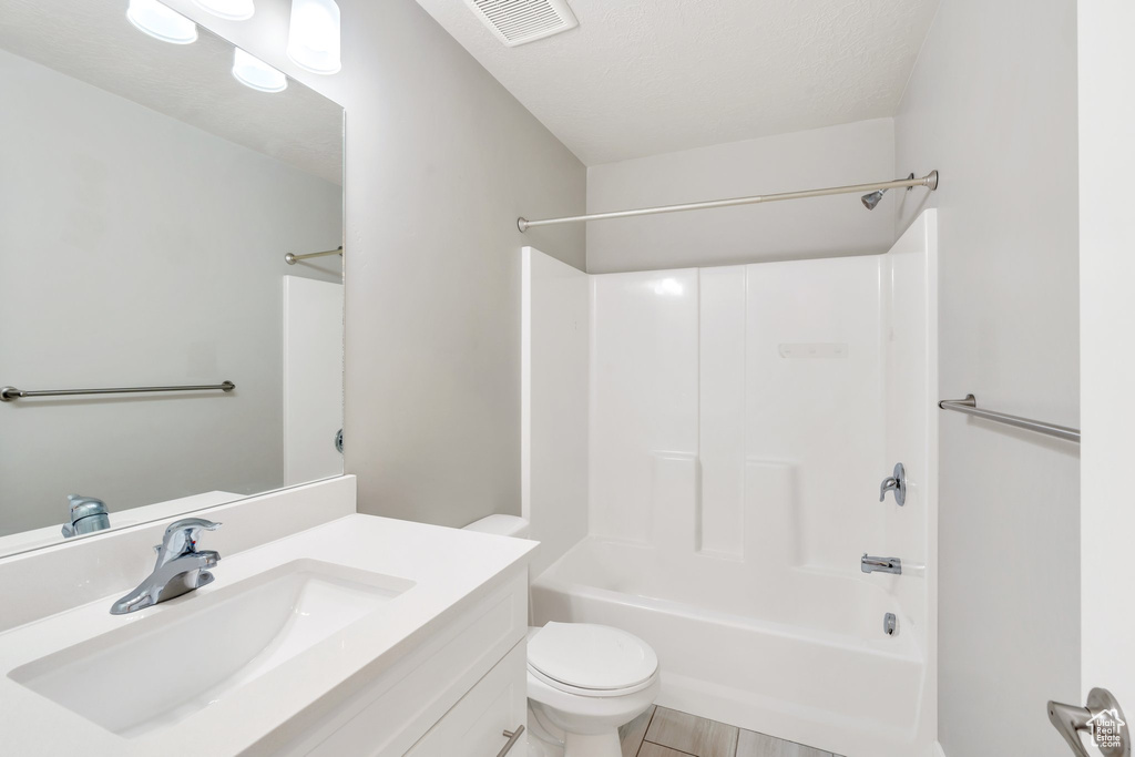 Bathroom featuring washtub / shower combination, toilet, and vanity