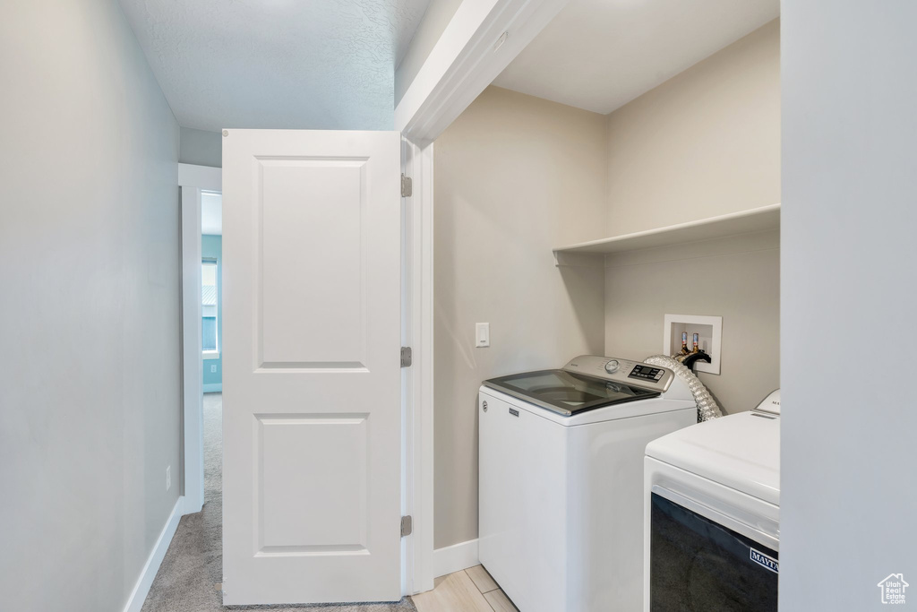 Laundry room with washer and clothes dryer and baseboards