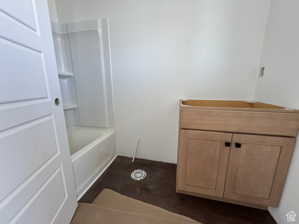 Bathroom featuring wood finished floors and shower / bathtub combination