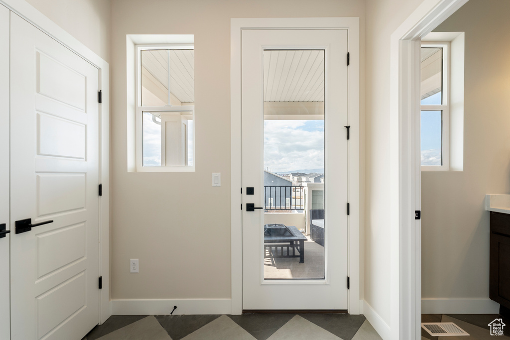 Doorway to outside featuring healthy amount of natural light and baseboards