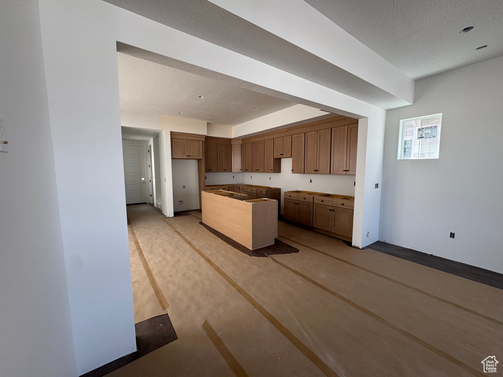Kitchen with a textured ceiling and a kitchen island