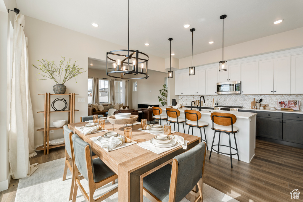 Dining area with light wood-style floors, a chandelier, and recessed lighting