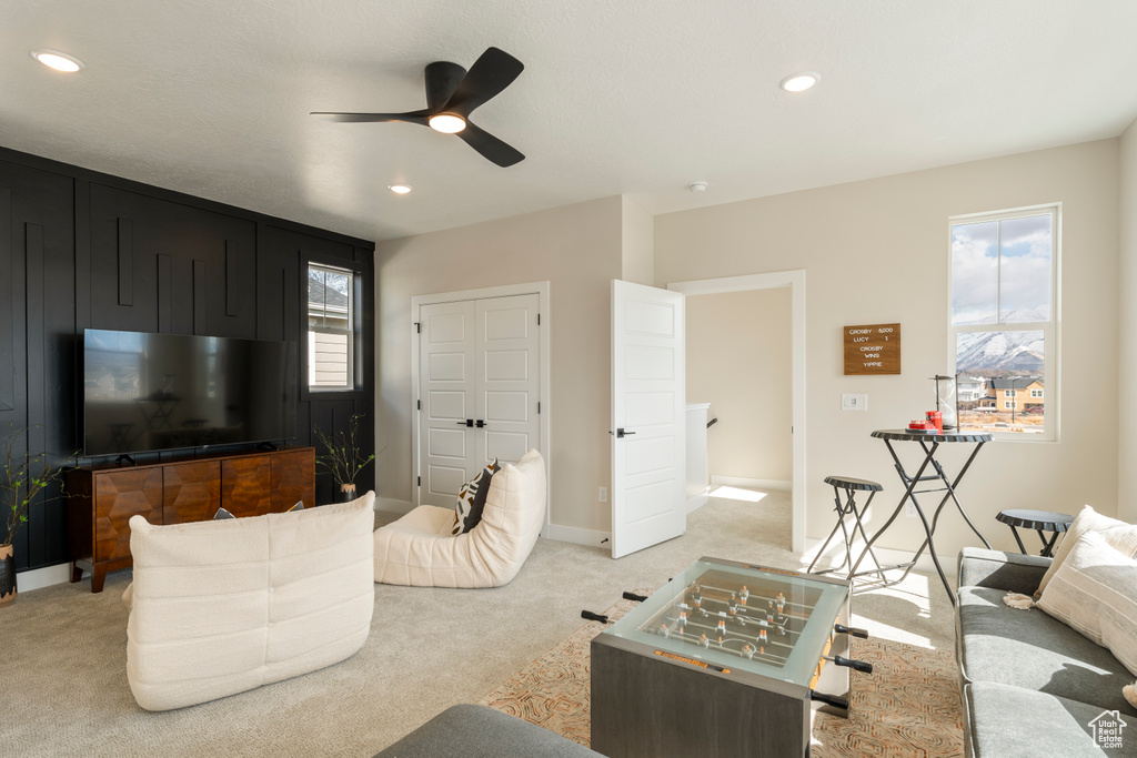 Living room featuring light carpet, a ceiling fan, recessed lighting, and baseboards