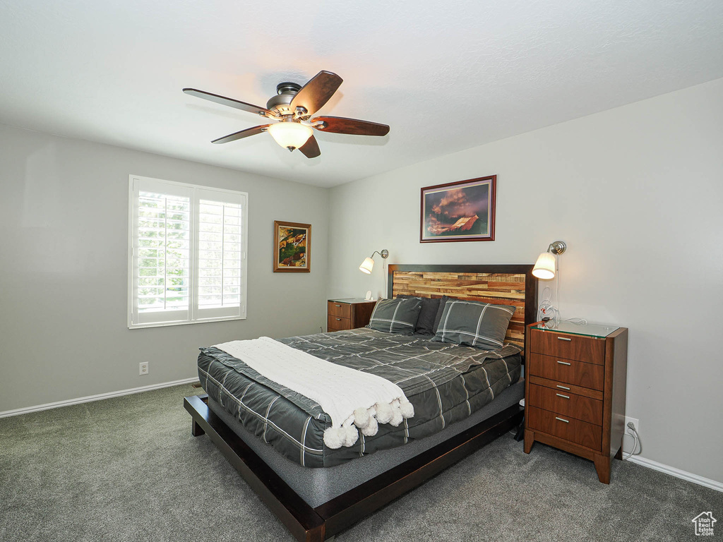 Carpeted bedroom featuring baseboards and ceiling fan