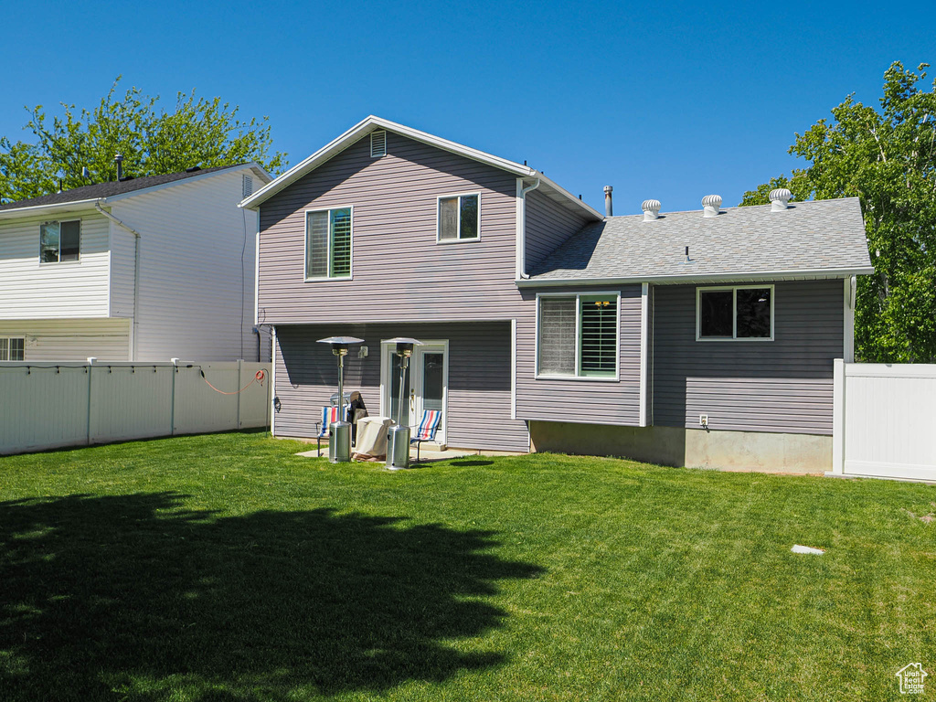 Rear view of house featuring a shingled roof