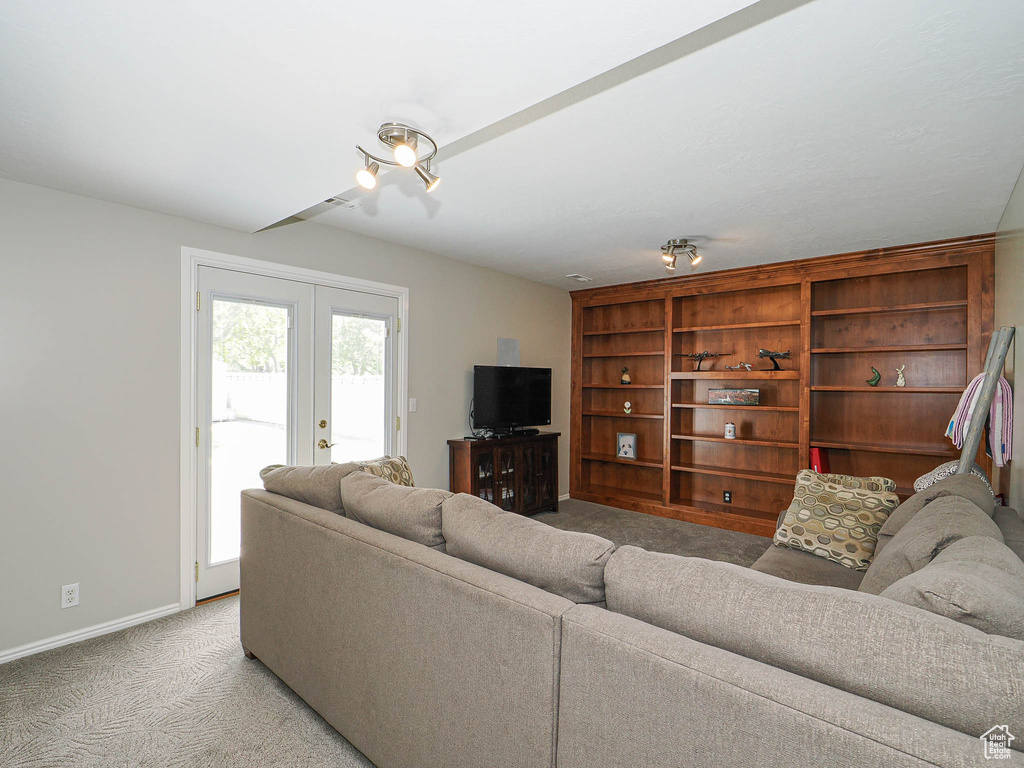 Living area with light carpet, french doors, and baseboards