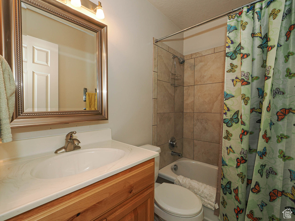 Full bathroom featuring shower / tub combo, toilet, and vanity