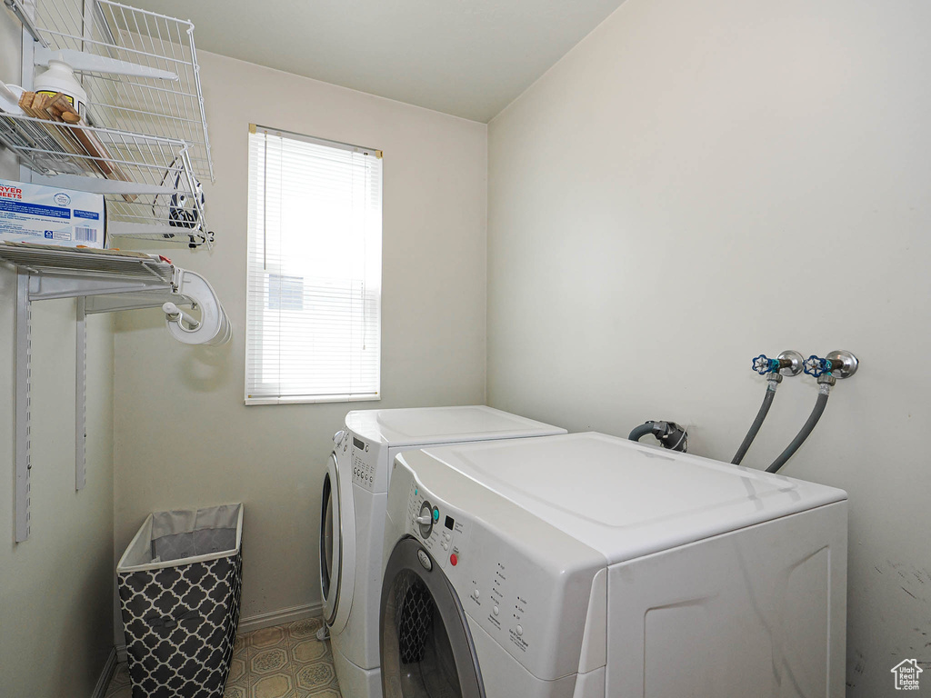 Laundry area with separate washer and dryer and baseboards