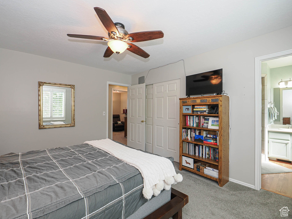 Bedroom with carpet floors, a closet, a ceiling fan, and ensuite bathroom