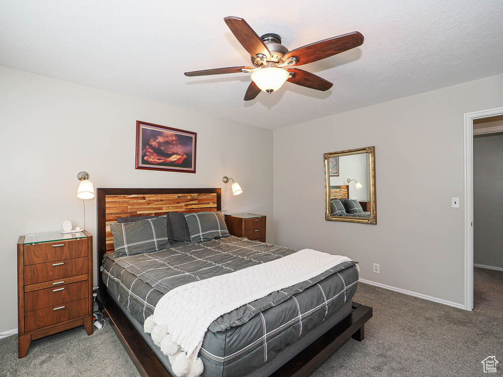 Carpeted bedroom with baseboards and a ceiling fan