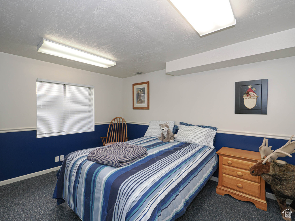 Bedroom with carpet flooring, a textured ceiling, and baseboards