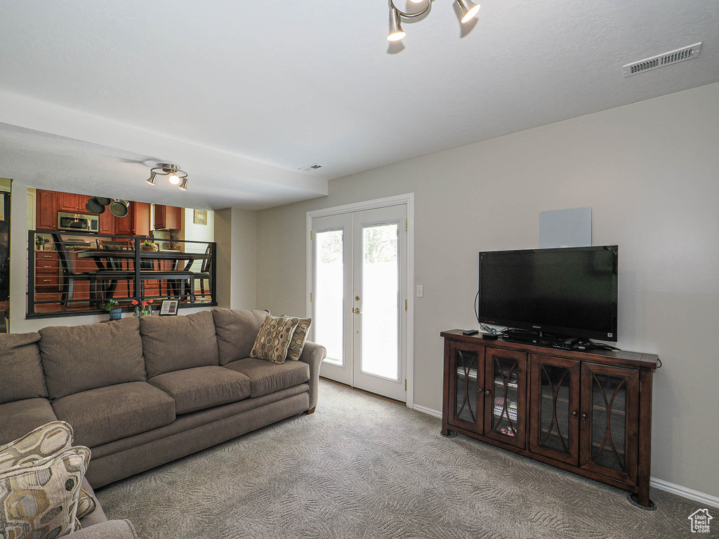 Living room with light carpet, french doors, and baseboards