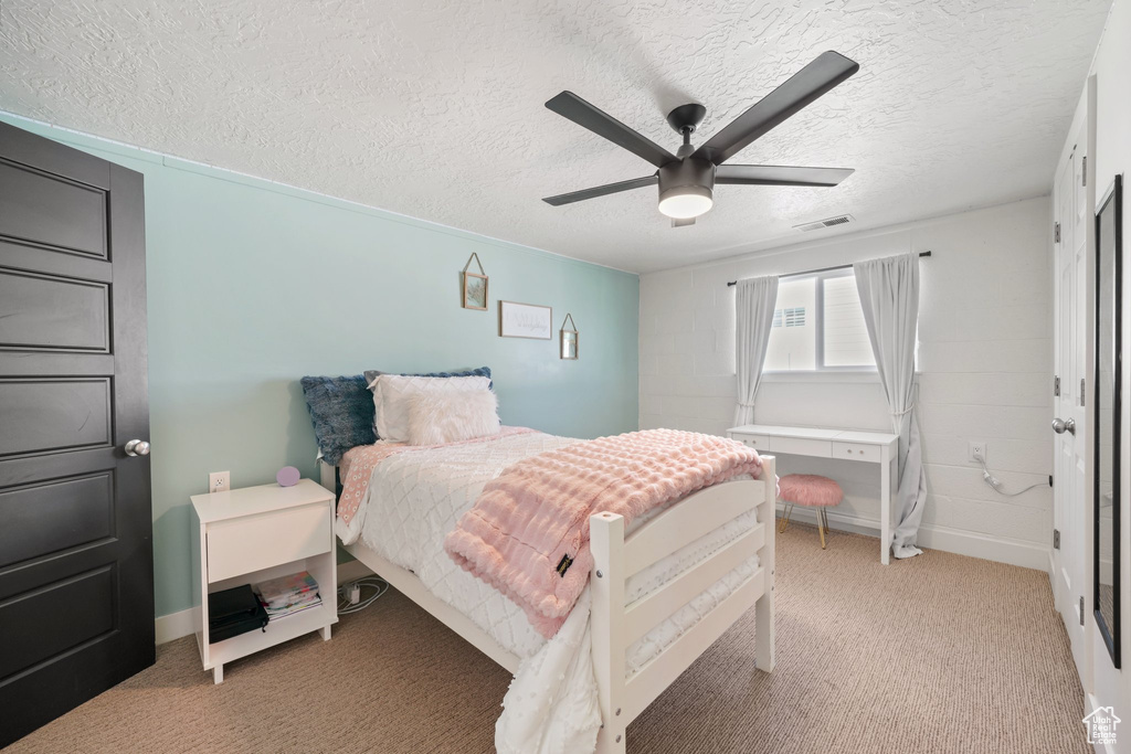 Bedroom featuring light carpet, a textured ceiling, ceiling fan, and baseboards
