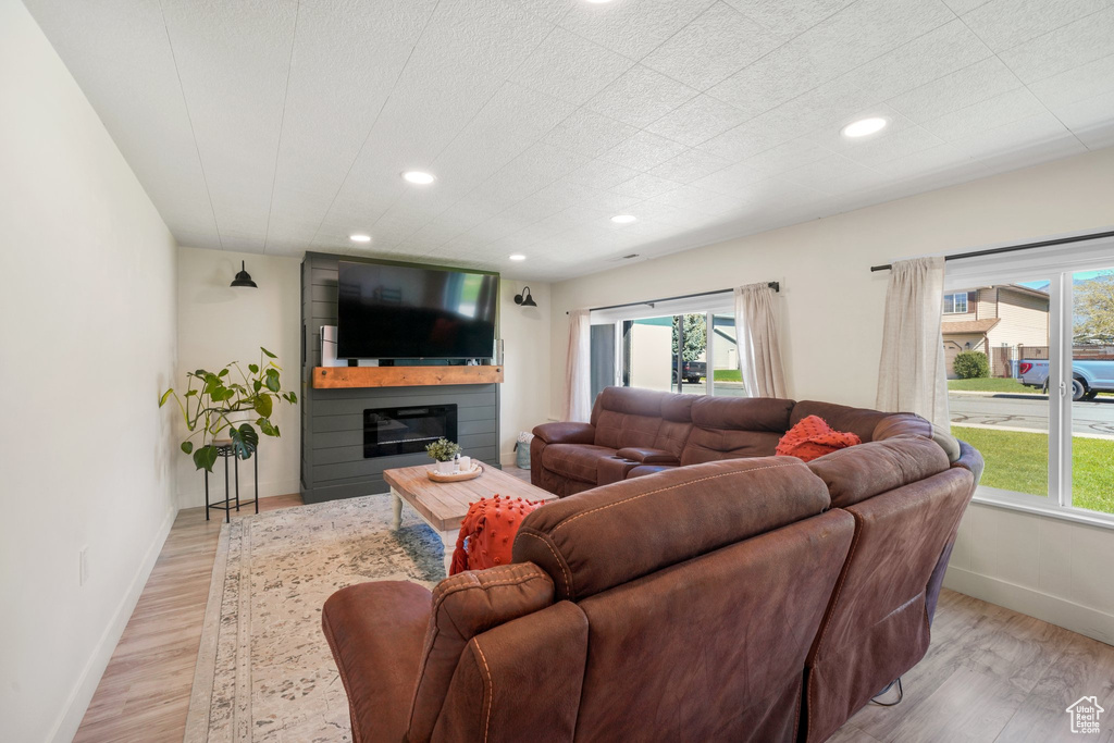 Living area featuring light wood-type flooring, baseboards, plenty of natural light, and recessed lighting