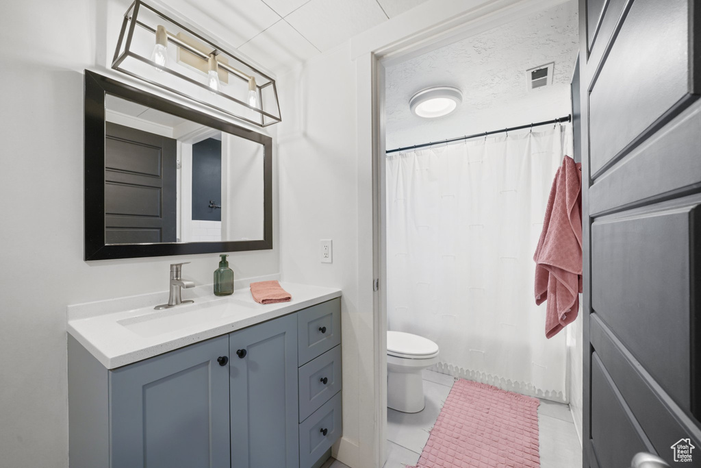 Bathroom with vanity, toilet, and a shower with shower curtain