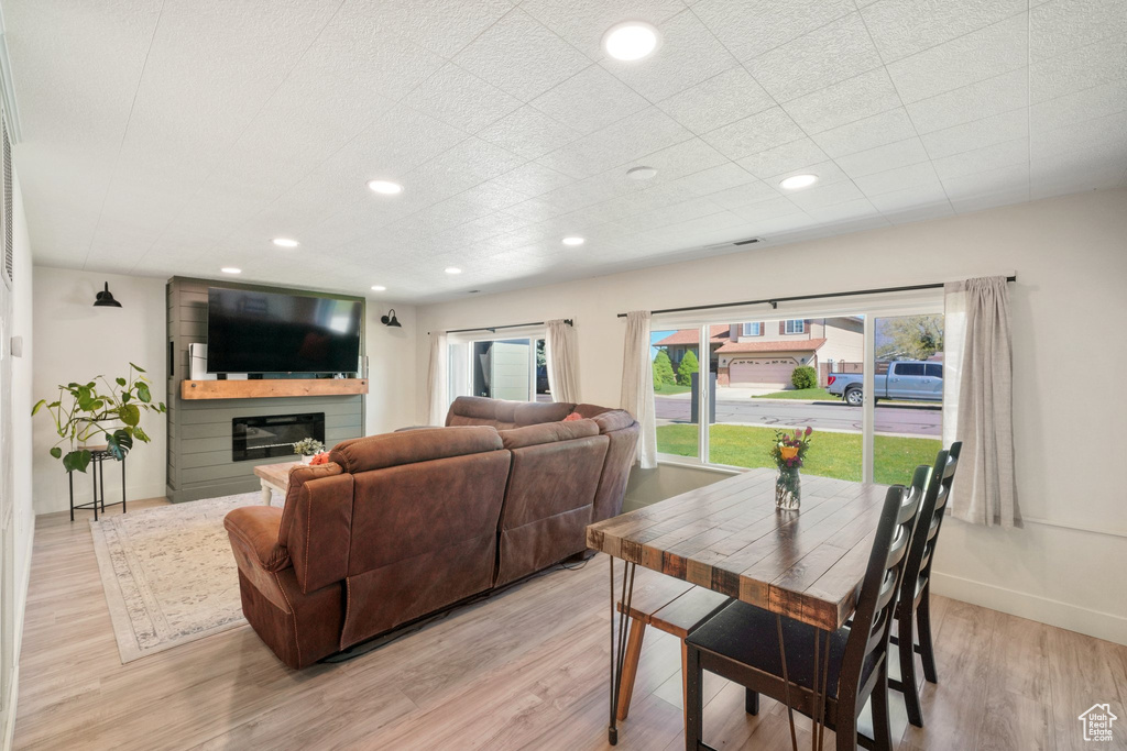Dining room featuring light wood-style flooring, recessed lighting, a glass covered fireplace, and baseboards