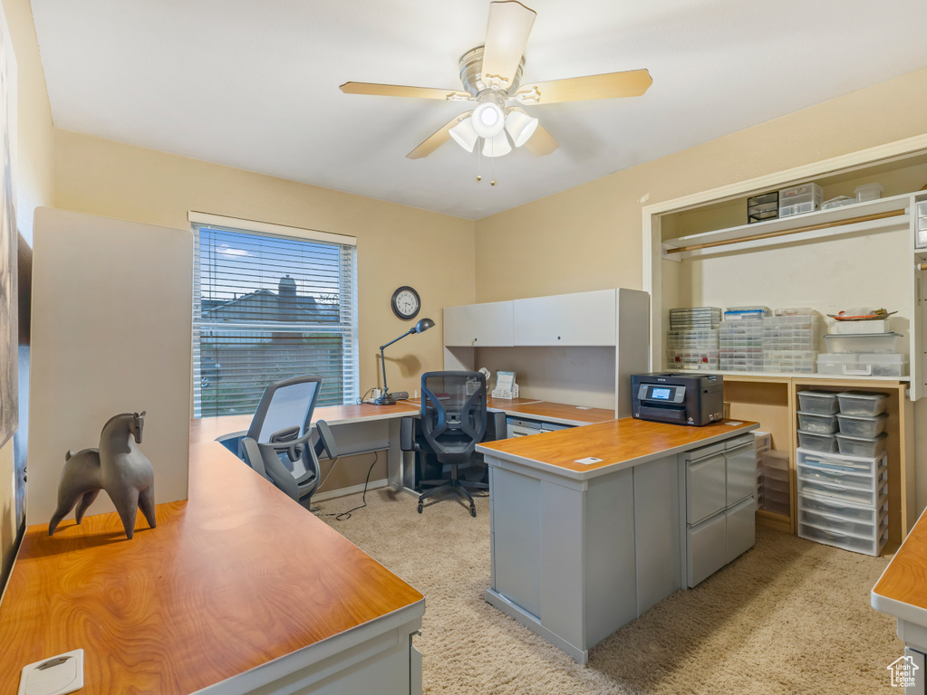 Office space with ceiling fan and light colored carpet