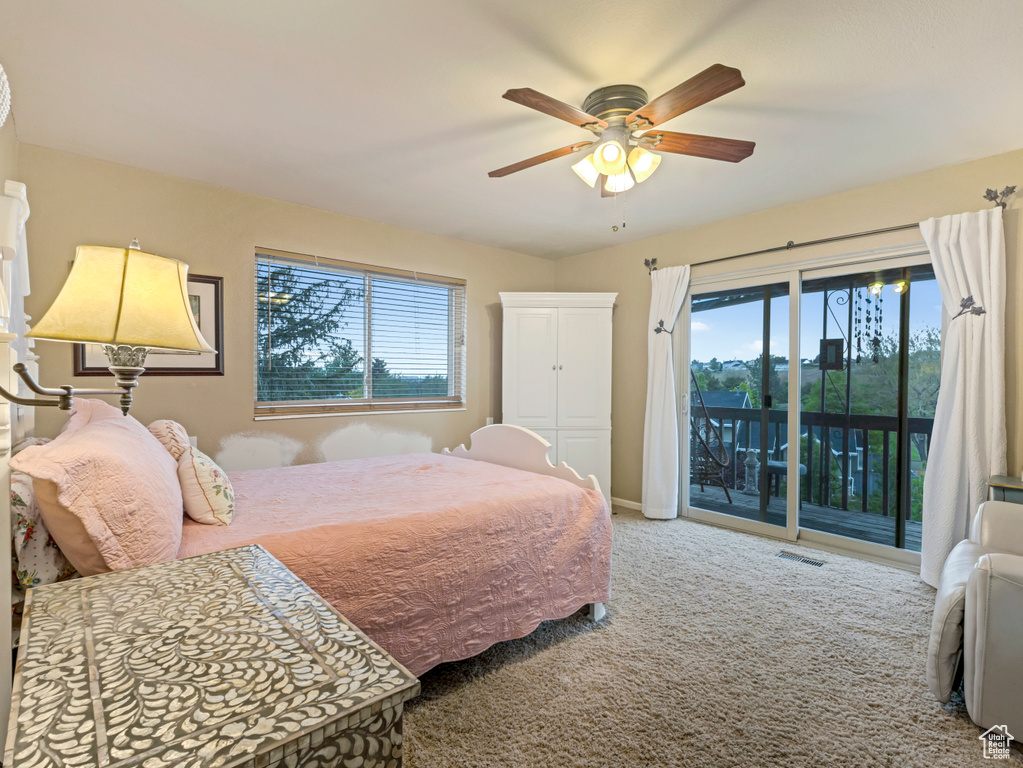 Bedroom featuring access to outside, carpet flooring, multiple windows, and a ceiling fan