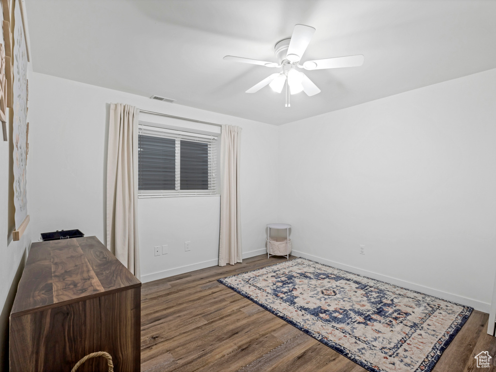 Spare room featuring wood finished floors, baseboards, and a ceiling fan