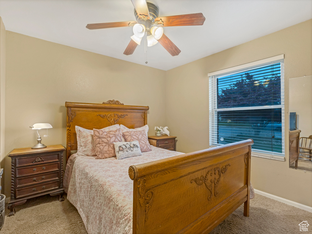 Bedroom featuring carpet floors, baseboards, and ceiling fan