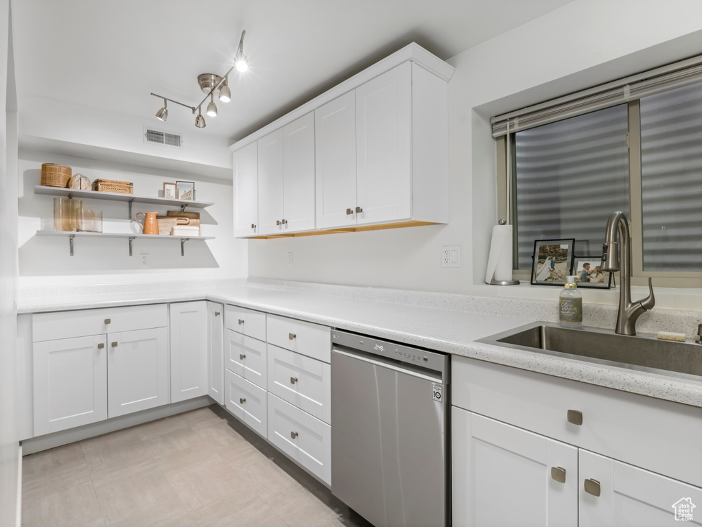 Kitchen with dishwasher, open shelves, light countertops, a sink, and white cabinetry