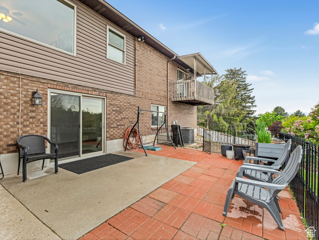 View of patio featuring a balcony, central AC, and fence