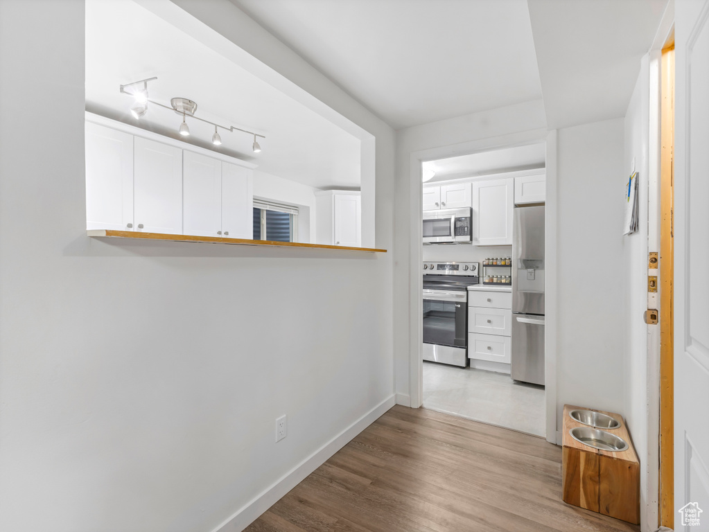 Hall with wood finished floors and baseboards
