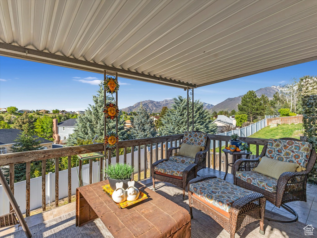 Wooden deck featuring a mountain view, a fenced backyard, an outdoor hangout area, and a patio