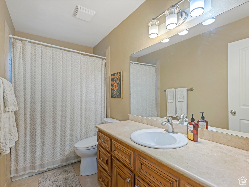 Bathroom featuring toilet, tile patterned floors, and vanity
