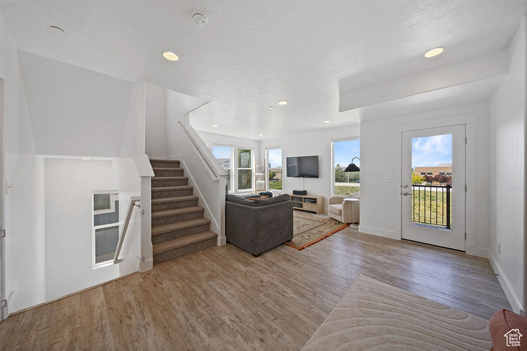 Living room featuring wood finished floors, stairs, recessed lighting, and baseboards