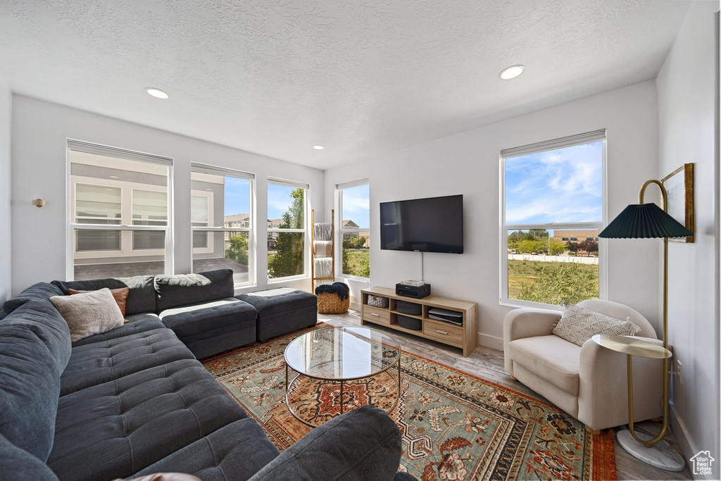 Living room with healthy amount of natural light, recessed lighting, baseboards, and a textured ceiling