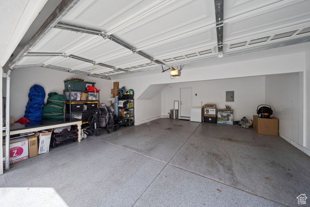 Garage featuring a garage door opener and electric panel