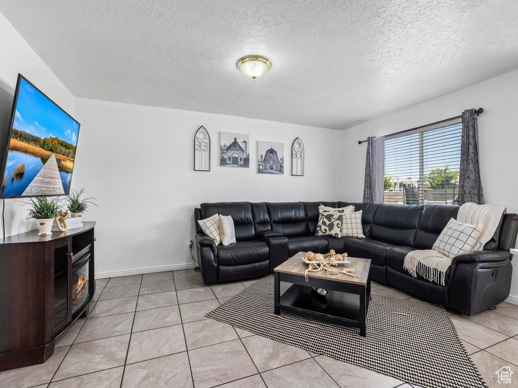 Living area with light tile patterned floors and a textured ceiling