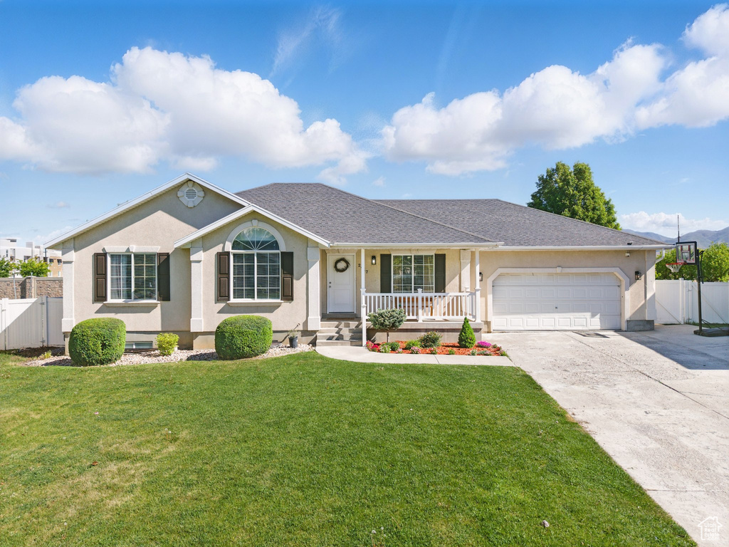Ranch-style home featuring covered porch, a gate, driveway, a garage, and stucco siding