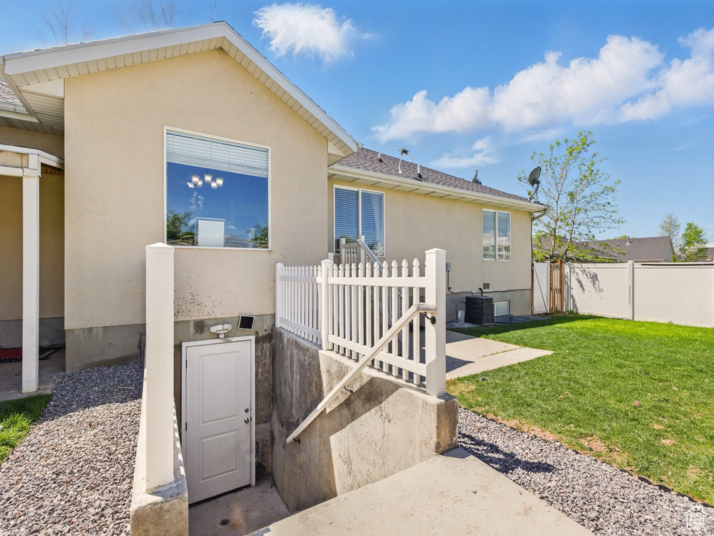 Back of house with stucco siding and central AC unit