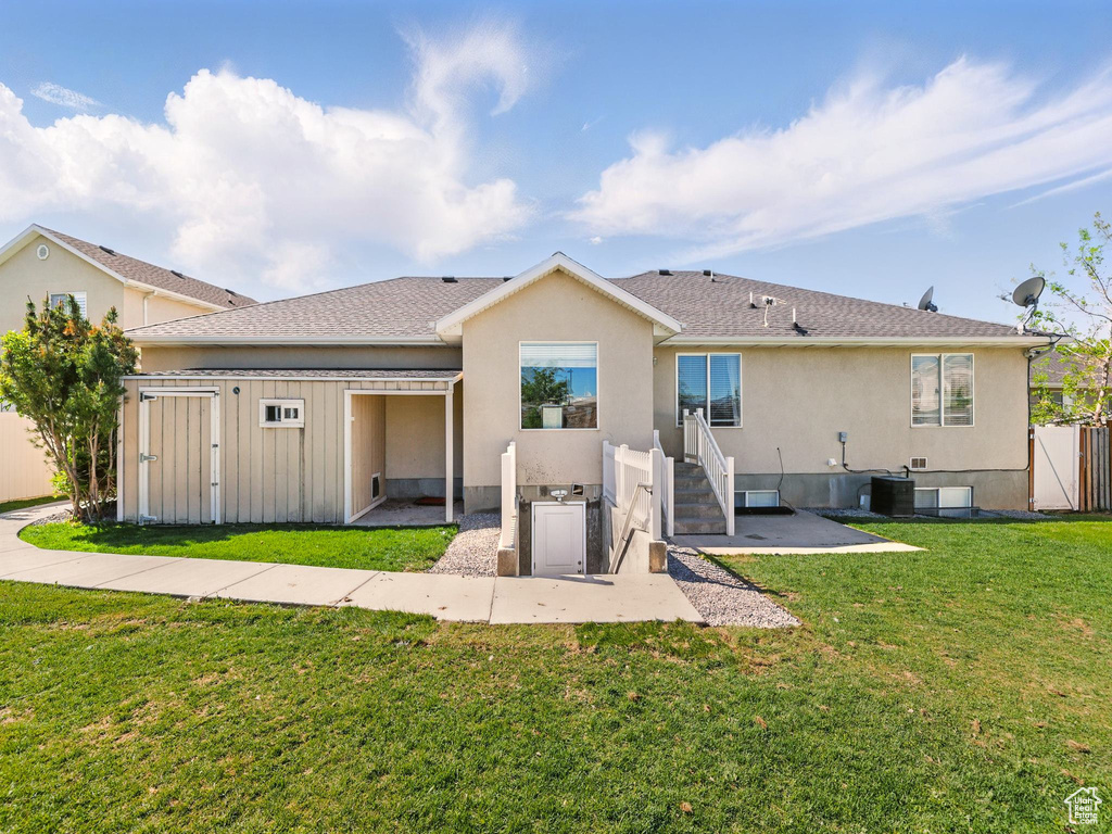 Rear view of house featuring stucco siding, cooling unit, a shingled roof, and a patio