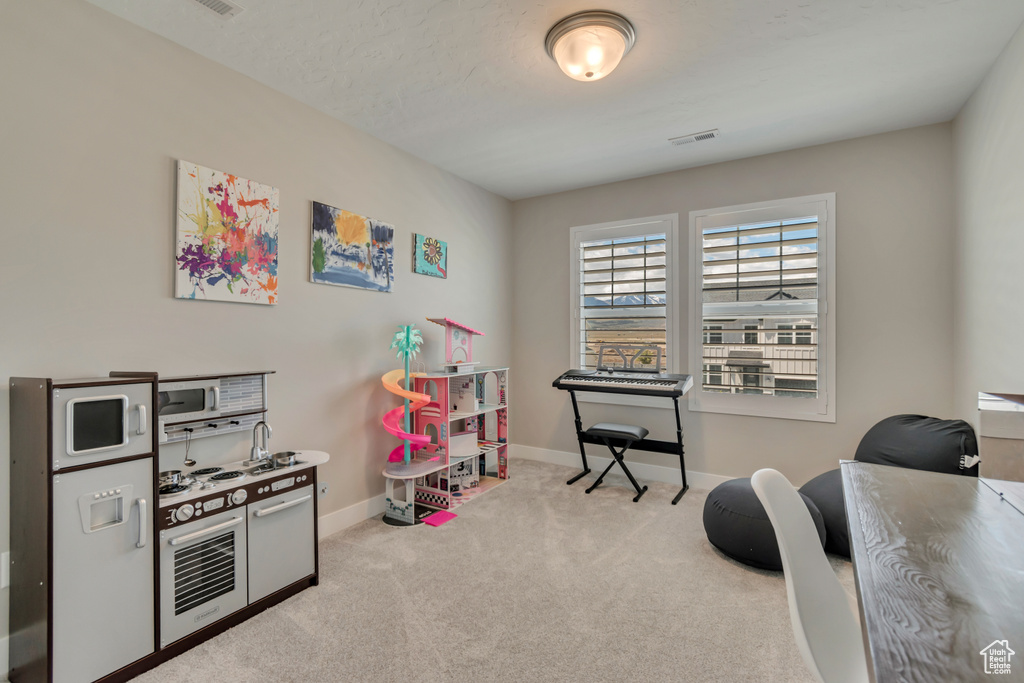 Playroom featuring carpet flooring, baseboards, and a desk