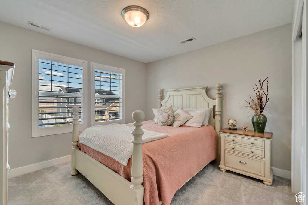 Bedroom with light carpet and baseboards
