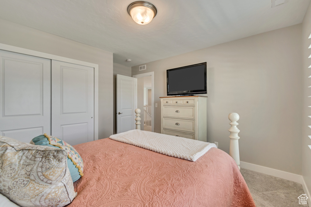 Bedroom with carpet flooring, a closet, and baseboards
