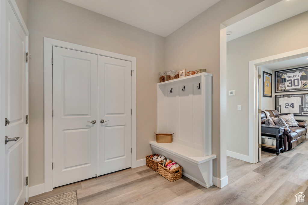 Mudroom with light wood-type flooring and baseboards