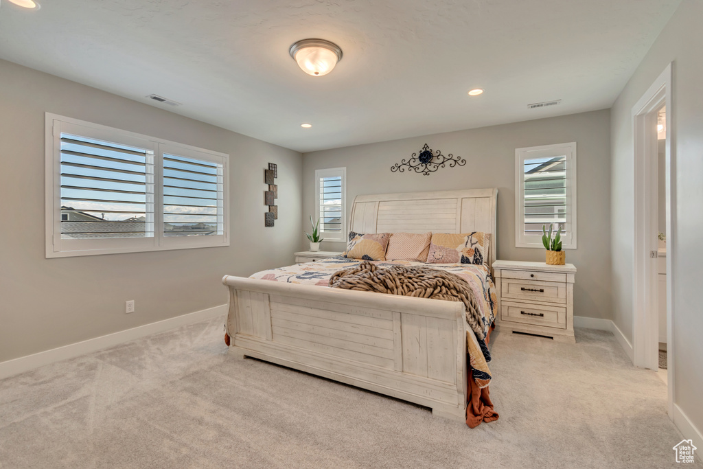 Bedroom featuring light colored carpet, multiple windows, baseboards, and recessed lighting