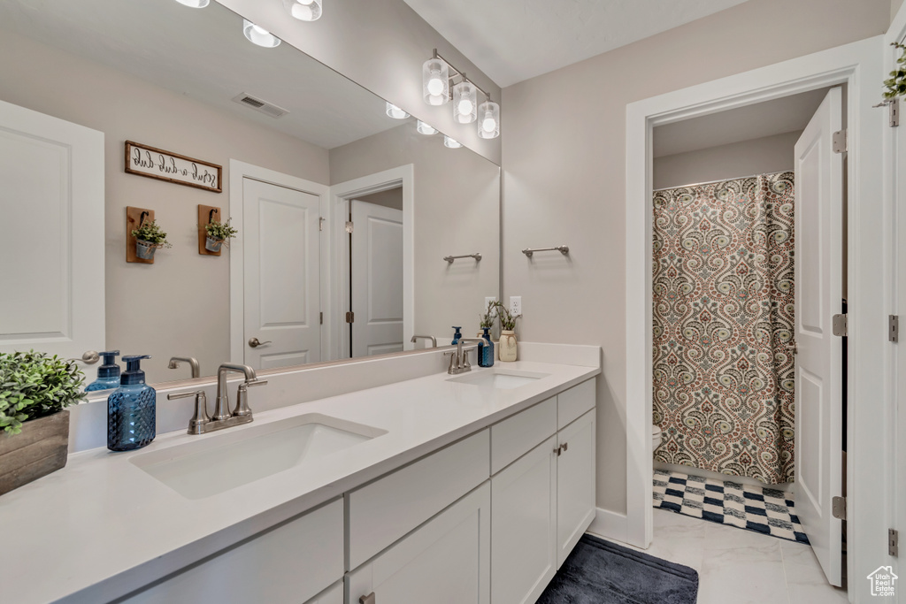 Bathroom with double vanity and a shower with shower curtain