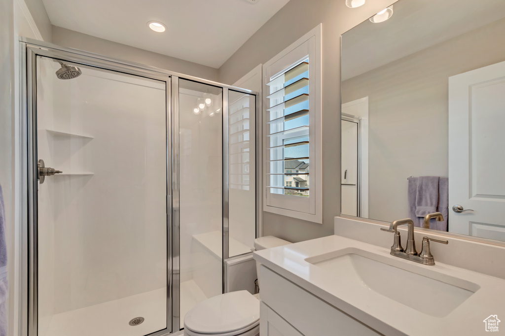 Full bathroom featuring a stall shower, toilet, and vanity