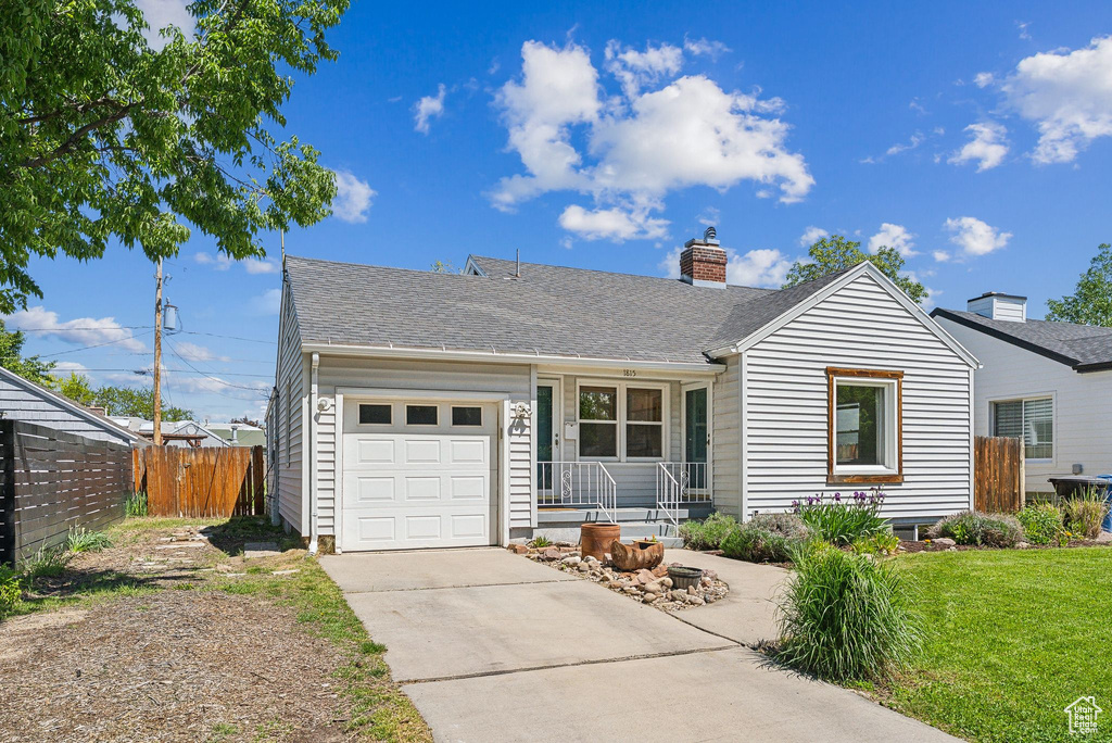 Single story home featuring concrete driveway, an attached garage, a chimney, and a shingled roof