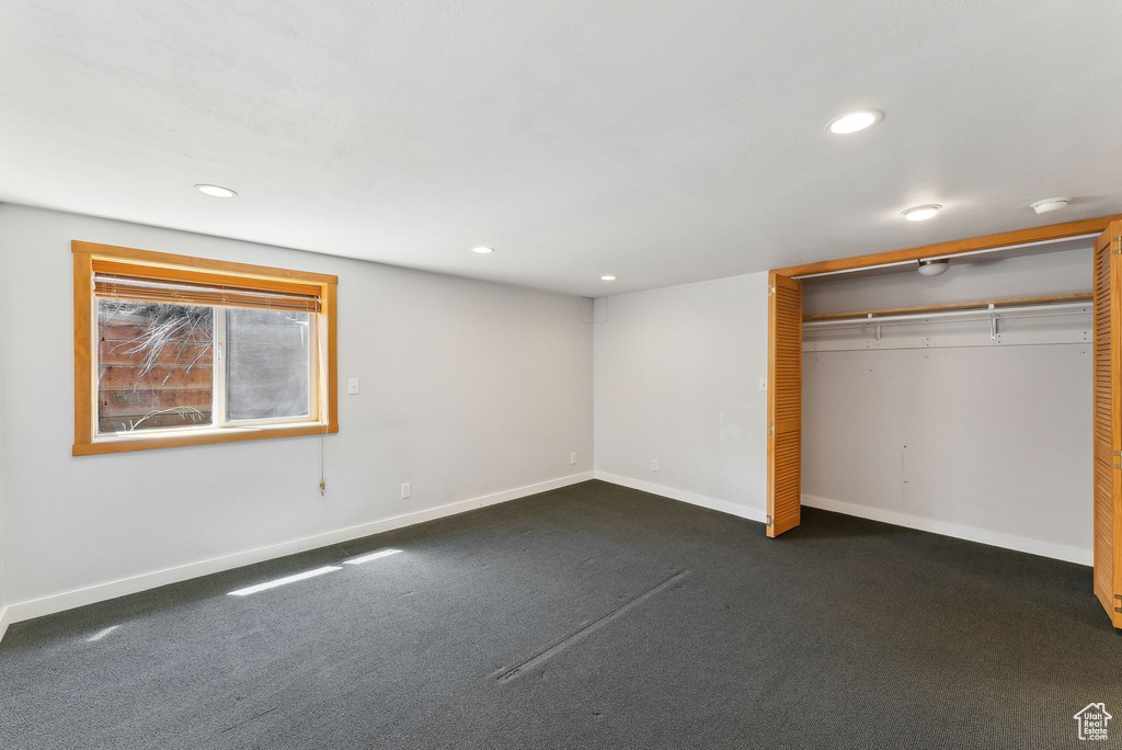 Unfurnished bedroom featuring baseboards, recessed lighting, a closet, and dark colored carpet