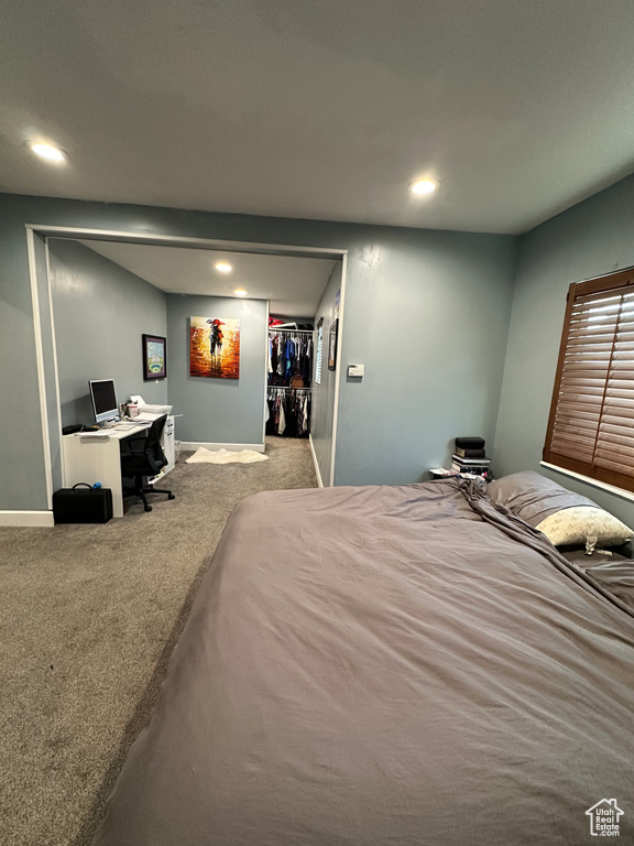 Bedroom featuring carpet, a desk, recessed lighting, baseboards, and a walk in closet