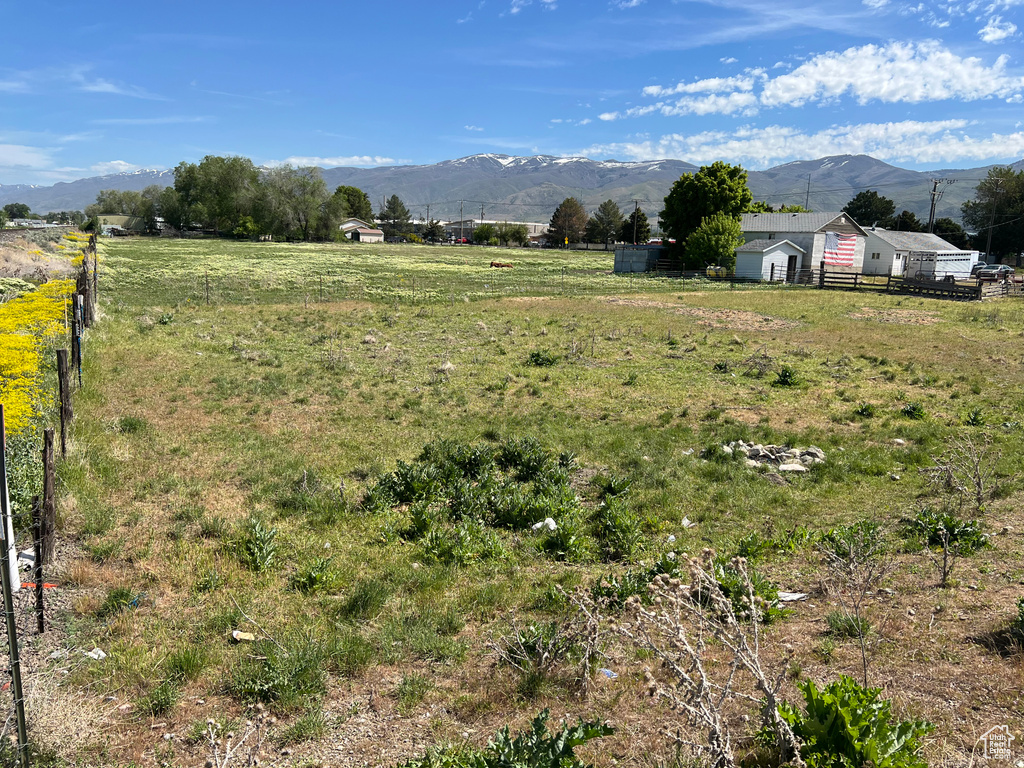 View of yard featuring a rural view, fence, and a mountain view